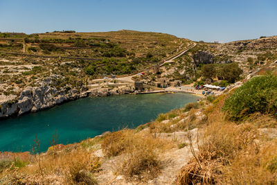 Scenic view of sea and mountains against clear blue sky