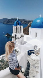 Woman standing on steps against church at santorini