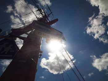 Low angle view of sun shining through clouds