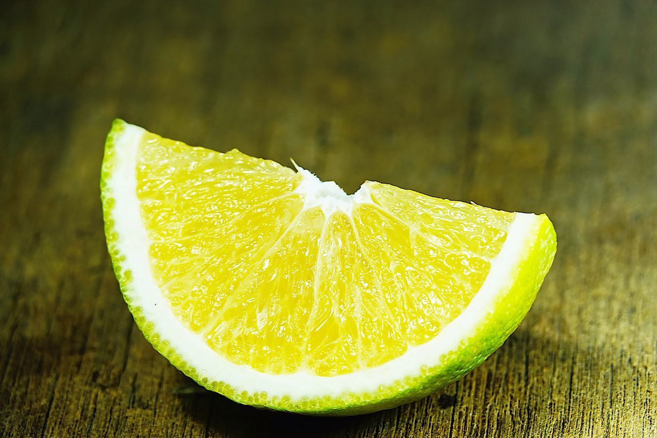 CLOSE-UP OF LEMON SLICE IN PLATE ON TABLE