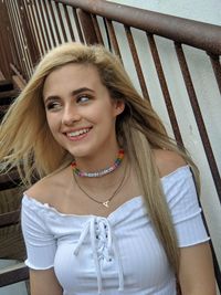 Low angle view of teenage girl sitting by railing on staircase