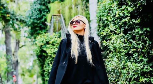 Portrait of woman standing against plants