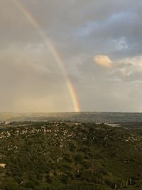 Scenic view of rainbow over land against sky