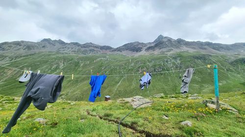 Clothes drying on clothesline on field against sky