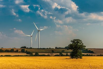 Windmill on field against sky