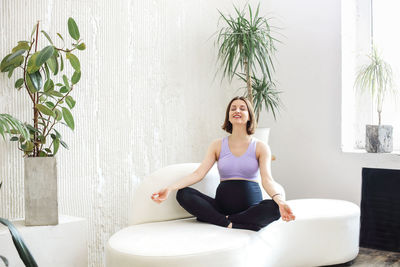 Young woman sitting on sofa at home