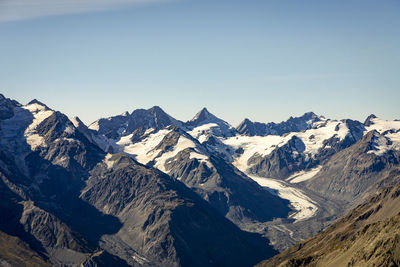 Scenic view of snowcapped mountains against clear sky