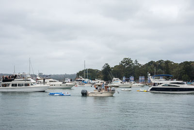 Boats moored at harbor against sky