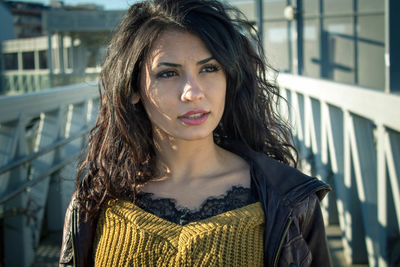 Beautiful woman looking away standing on footbridge