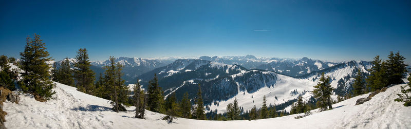 Panoramic view of snowcapped mountains against clear blue sky