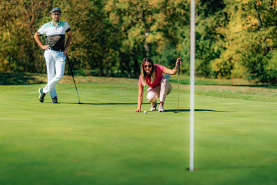 Woman playing golf, reading the green