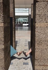 Low section of woman against building wall