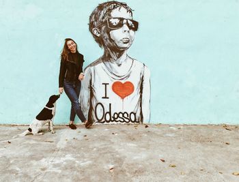 Woman standing against graffiti wall