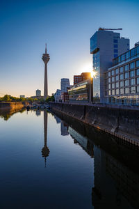 Reflection of buildings in city at sunset