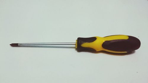 High angle view of paintbrushes on table against white background