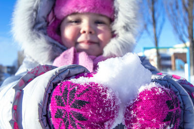 Close-up of child holding snow