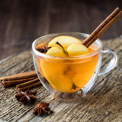 Hot apple cider garnished with a cinnamon stick, star anise and apple slices.
