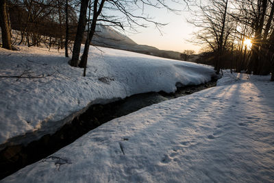 Scenic view of snow covered land against sky