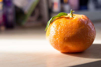 Tangerine on wooden table with direct sunlight side light. copy space