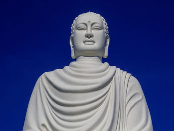 Low angle view of statue against blue sky