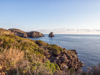 Scenic view of rocks in sea against sky