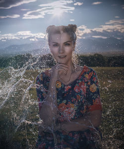 Portrait of beautiful woman standing against water