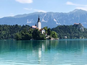 Scenic view of lake by buildings against sky