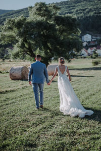 Rear view of couple kissing on field