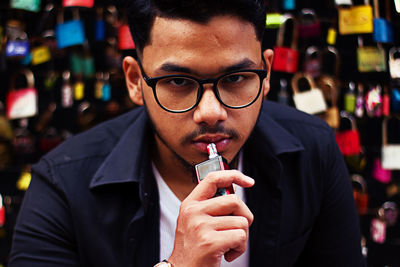 Portrait of young man smoking electronic cigarette