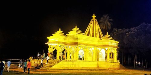 Group of people in temple against sky at night