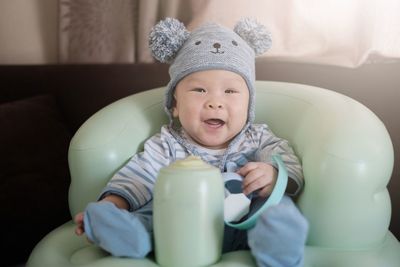 Portrait of cute boy drinking glass at home