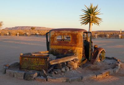 Abandoned truck on field against clear sky