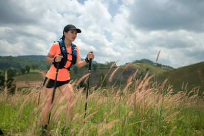 Young woman walking on grassy land