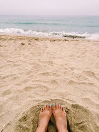 Low section of person relaxing on beach