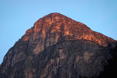 Low angle view of rock formation against clear blue sky