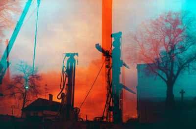 Double exposure image of bare trees against sky during sunset