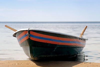 Boat moored on beach against sky