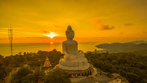 Statue of temple against sky during sunset