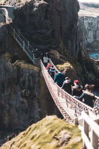 People on footbridge over rock formation