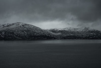 Scenic view of lake against storm clouds