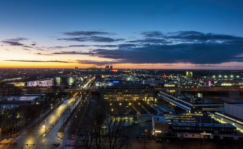 High angle view of illuminated cityscape against sky at sunset