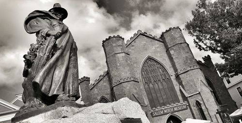Low angle view of statue against building against sky
