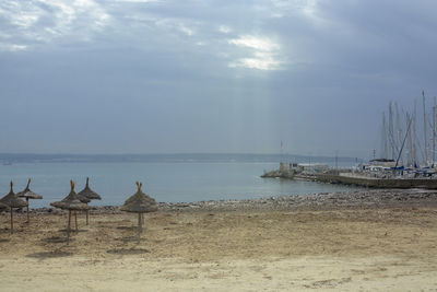 Sailboats on beach against sky