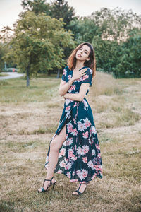 Portrait of smiling young woman standing on field