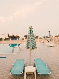 Rear view of chairs on beach against clear sky