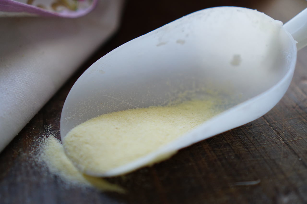 HIGH ANGLE VIEW OF EGG IN CONTAINER ON TABLE