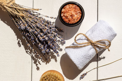 Spa composition with beautiful lavender and sea salt on white wooden table.