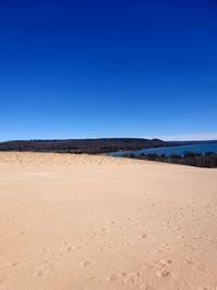 Scenic view of desert against clear blue sky