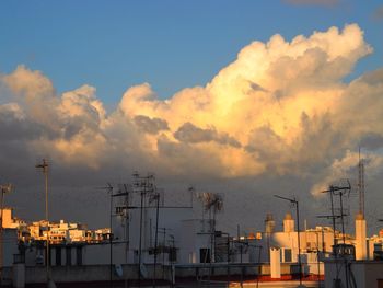 Buildings against cloudy sky at sunset