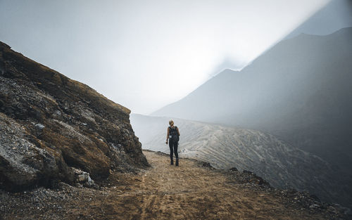 Man standing on mountain against sky